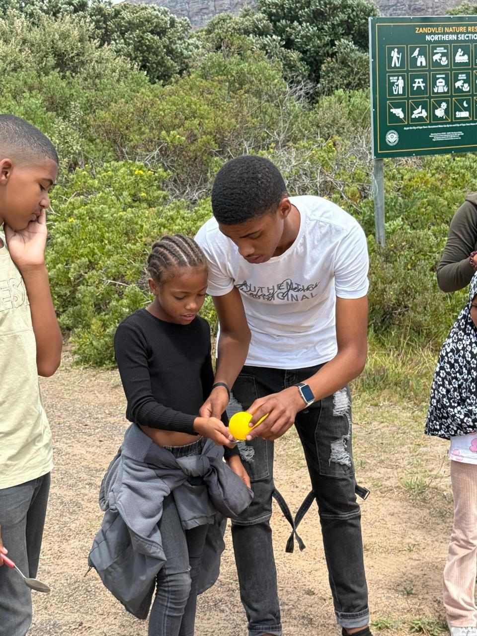 Helping a younger member of the programme on an outing