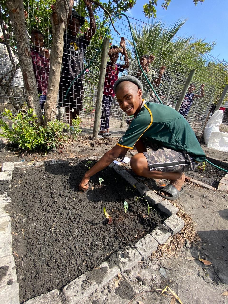 Zacri planting seedlings at a community garden session